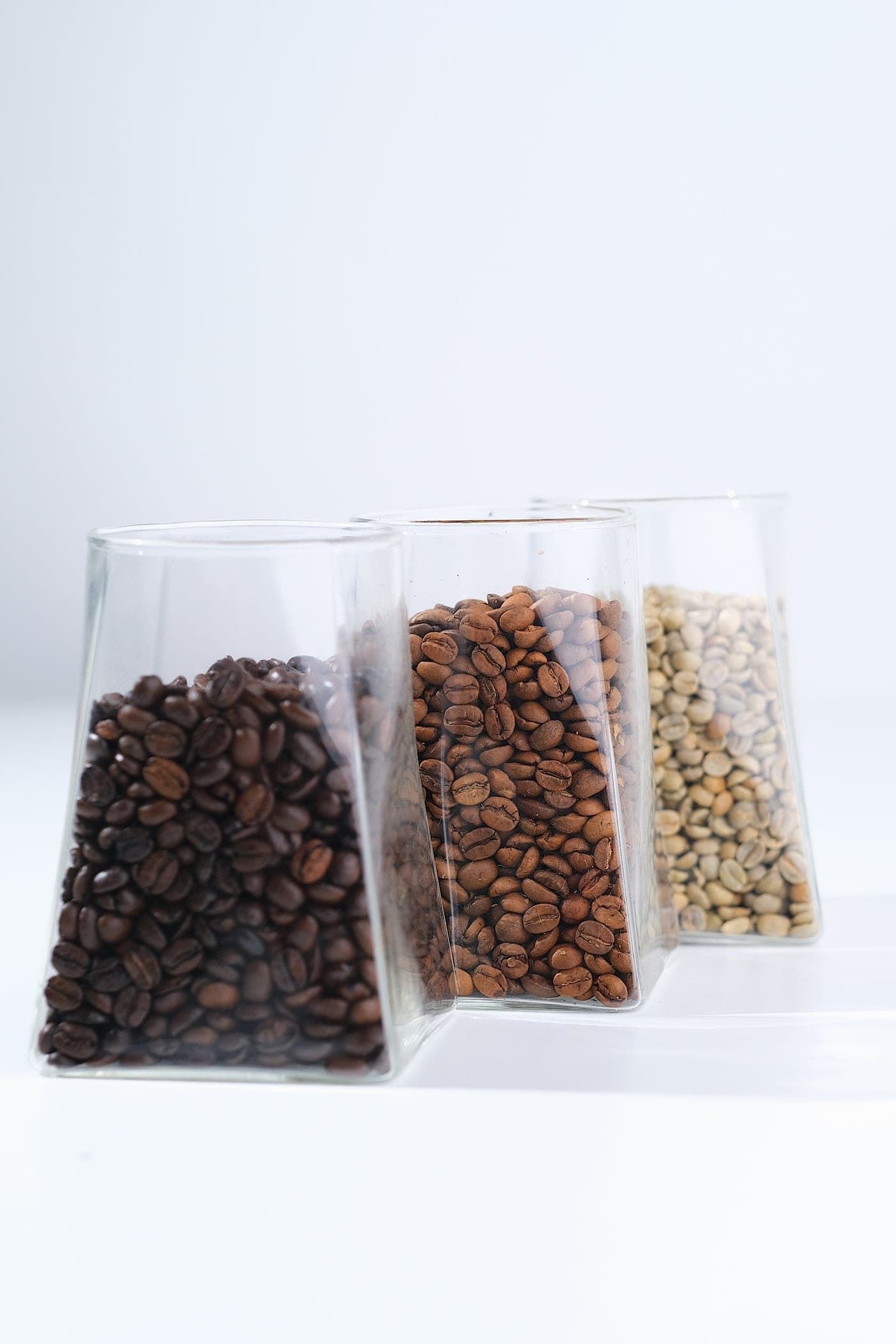 Three glass pouches of coffee beans in different colours
