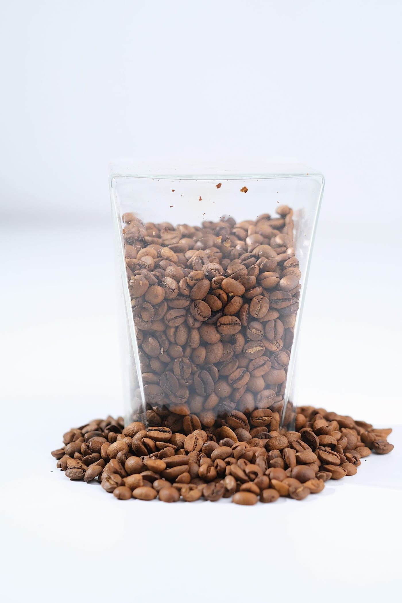 A glass pouch of coffee beans standing in a pile of beans